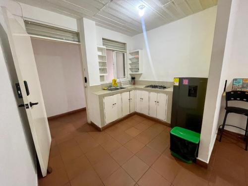 a kitchen with white cabinets and a black refrigerator at OUR HOME SAN ANTONIO in Cali