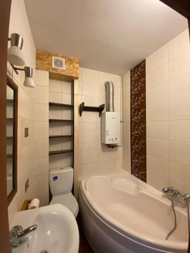 a bathroom with a tub and a toilet and a sink at Apartament Celna in Nysa