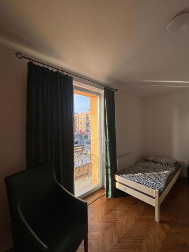 a bedroom with a bed and a large window at Apartament Celna in Nysa