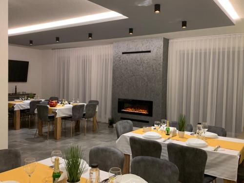 uma sala de jantar com mesas e cadeiras e uma lareira em Vila Diamond Lux&Spa em Sovata