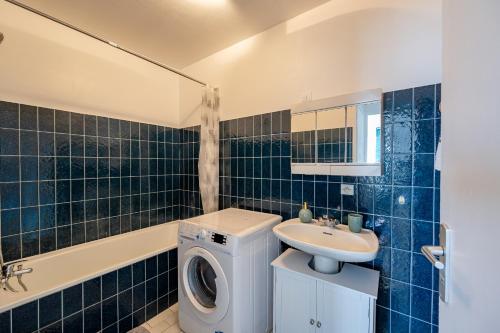 ein Badezimmer mit einer Waschmaschine und einem Waschbecken in der Unterkunft Perle Parisienne, Vue Captivante in Saint-Ouen