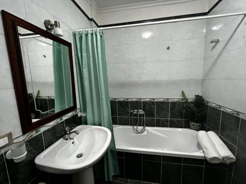 y baño con lavabo, bañera y espejo. en Appartamento Anastasia, en Monteroni di Lecce