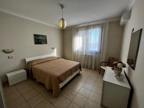 1 dormitorio con cama, mesa y ventana en Appartamento Anastasia, en Monteroni di Lecce