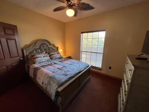 Schlafzimmer mit einem Bett und einem Deckenventilator in der Unterkunft Cotton Port on the Ouachita River in West Monroe