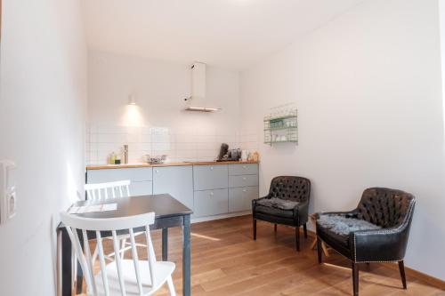 a kitchen with two chairs and a table in a room at Zaunkönig Apartments in Baden-Baden