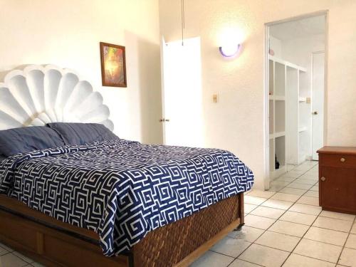 阿卡普爾科的住宿－Casa Acapulco Bello，一间卧室配有一张带蓝色和白色棉被的床