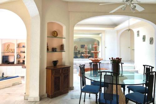阿卡普爾科的住宿－Casa Acapulco Bello，一间设有玻璃桌和椅子的用餐室