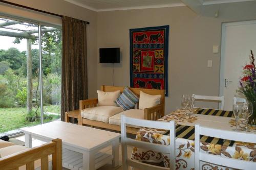 a living room with a couch and a table at Cuckoo's Corner in Bettyʼs Bay