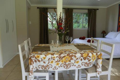 a dining room with a table and two beds at Cuckoo's Corner in Bettyʼs Bay