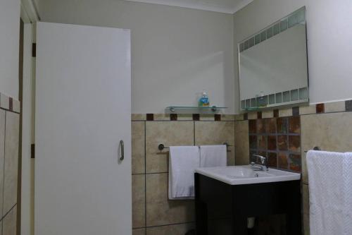 a bathroom with a sink and a mirror at Cuckoo's Corner in Bettyʼs Bay