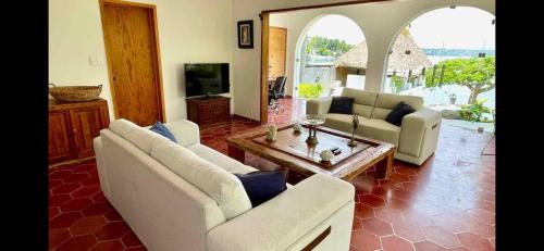 a living room with two couches and a table at Casa del Castillo in Tequesquitengo
