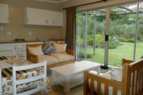 a living room with a couch and a table at Cuckoo's Corner in Bettyʼs Bay