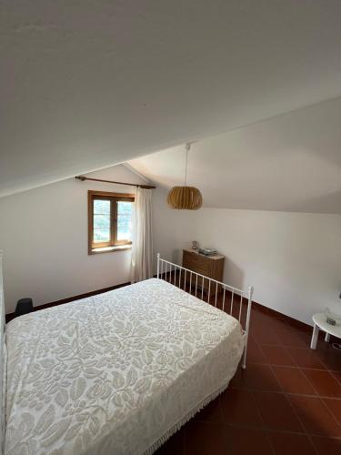 - une chambre avec un lit blanc et une fenêtre dans l'établissement Casa da Leira, à Resende