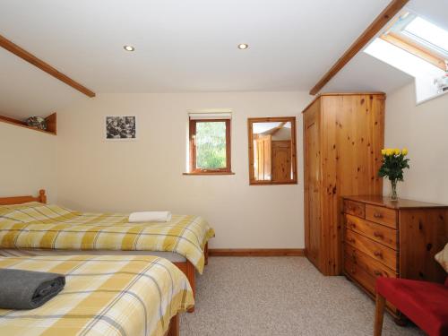 a bedroom with two beds and a wooden dresser at Poppy's Barn in Launceston