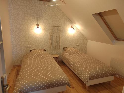 2 camas en una habitación pequeña con 2 lámparas en Appartement indépendant avec extérieur en Epfig