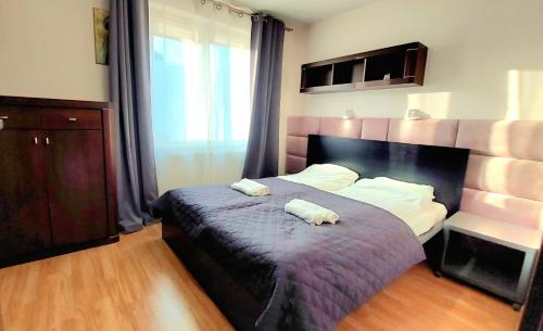a bedroom with a bed with two towels on it at Morza Szum Jantar TriApart in Jantar