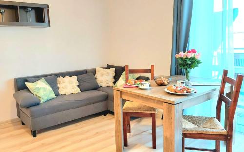 a living room with a couch and a table with food on it at Morza Szum Jantar TriApart in Jantar