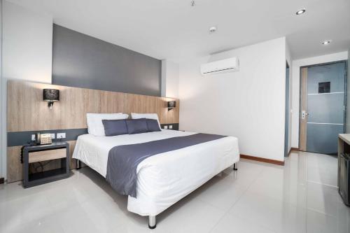 a bedroom with a large bed and a television at Hotel Plaza del Lili in Cali