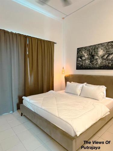 a bedroom with a large bed with white sheets at View of Putrajaya in Putrajaya