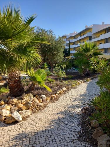 a cobblestone path with palm trees and a building at Portugal Home in Lagos