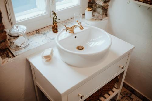La salle de bains est pourvue d'un lavabo blanc et d'une fenêtre. dans l'établissement Country house Harmonia, à Modra