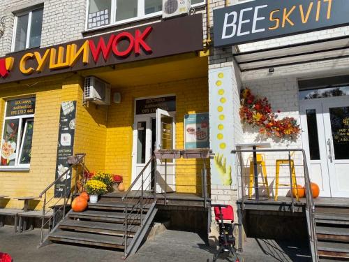 un edificio amarillo con un cartel en la parte delantera en Classic Apartment, en Boryspilʼ