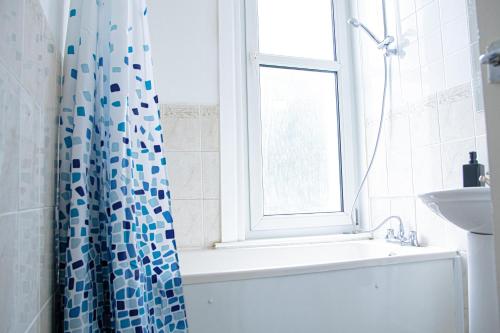 bagno con tenda per la doccia e lavandino di Central Dover Apartment 1 a Kent