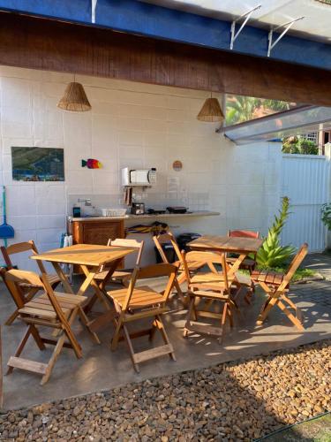 a group of wooden tables and chairs on a patio at Ao Mar - Hospedagem in São Sebastião