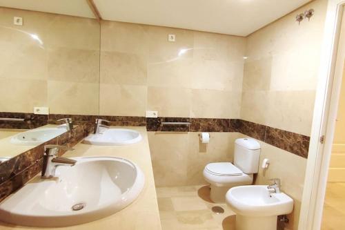 La salle de bains est pourvue de 2 lavabos, de toilettes et d'une baignoire. dans l'établissement Apartamento en Birdie Club, à San Roque