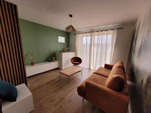 a living room with a couch and a table at L'Alambic à Martial in Ménétru-le-Vignoble