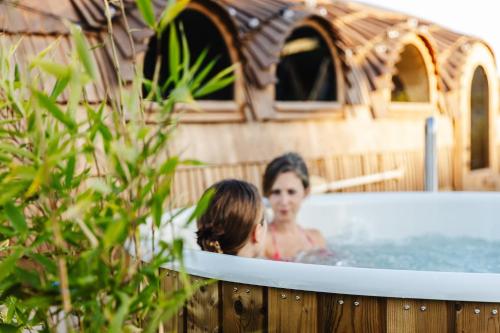 two women in a hot tub in a house at Premium Ferienhaus Das Farmhaus - Auf den Moselhöhen - Pool, Sauna, Kino, Garten in Lieg