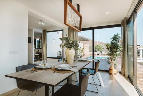 een eetkamer met een houten tafel en stoelen bij Villa Faro in Playa Blanca