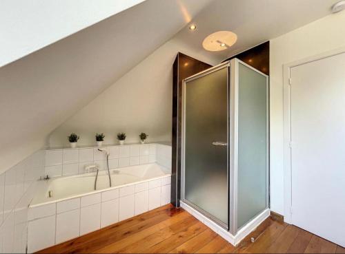 a bathroom with a shower and a bath tub at Residence Dunes et Mer in Koksijde