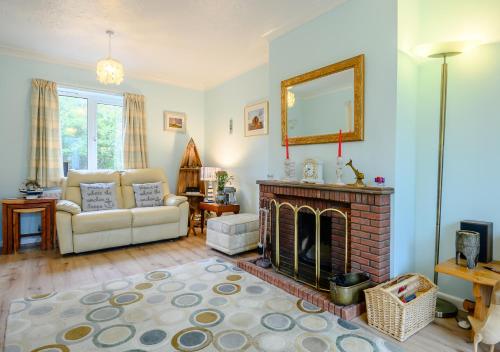 a living room with a couch and a fireplace at Rainbow Cottage in Thorpeness