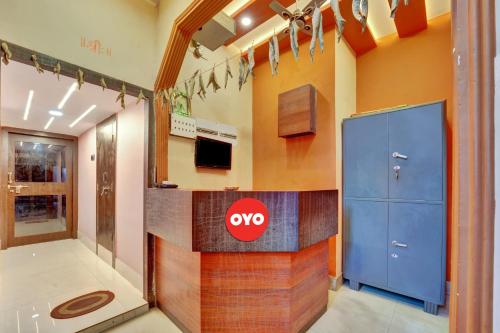 een kamer met een tv en een blauwe locker bij OYO Flagship Darsh Residency in Dhanbad