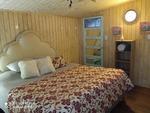 - une chambre avec un grand lit et une télévision dans l'établissement Familiar Hostal, à Chillán