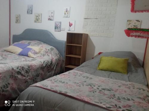 - 2 lits installés l'un à côté de l'autre dans une chambre dans l'établissement Familiar Hostal, à Chillán