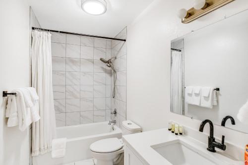 a white bathroom with a tub and a toilet and a sink at Bear Necessities in Eagle River