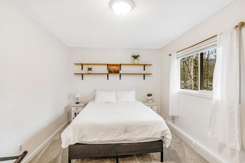 a white bedroom with a bed and a window at Bear Necessities in Eagle River