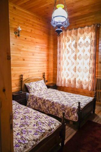 two beds in a room with wooden walls at Hôtel les truites in Imouzzer Kandar