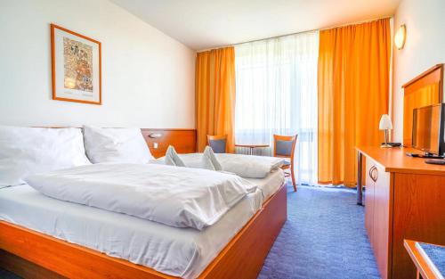 una camera d'albergo con letto e TV di Hotel RYSY a Tatranska Strba