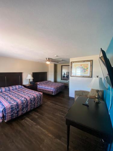 a hotel room with two beds and a table at La Hacienda Hotel in Laredo