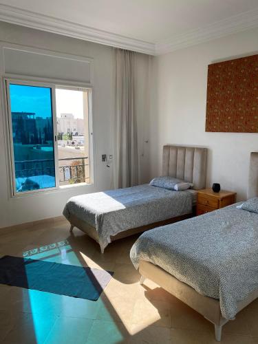 a hotel room with two beds and a window at apartement Lac 2 in El Aouina