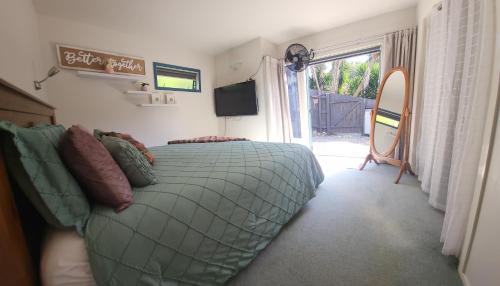 a bedroom with a bed and a tv and a window at Mi Castillo on Hatea Drive in Whangarei
