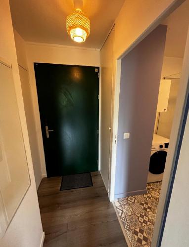 un couloir avec une porte verte et un tapis dans l'établissement Appartement Nautilus, à Équemauville