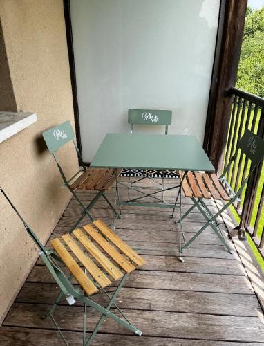- une table et des chaises sur une terrasse couverte avec un banc dans l'établissement Appartement Nautilus, à Équemauville