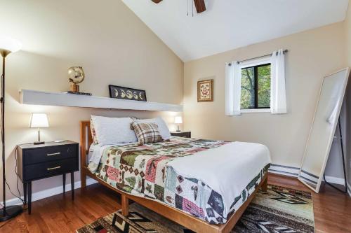 a bedroom with a bed and a window at Hot Tub, Fire Pit and Barrel Sauna Poconos Abode in Long Pond