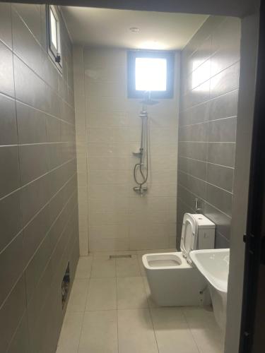 bagno con servizi igienici, lavandino e finestra di Mondialaw a Toubab Dialaw