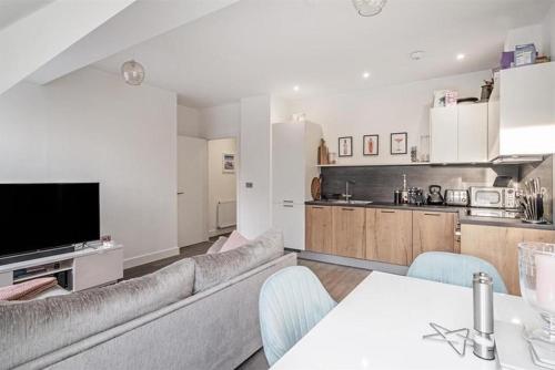 a living room with a couch and a kitchen at Solihull Town Centre Spacious Studio Apartment in Solihull