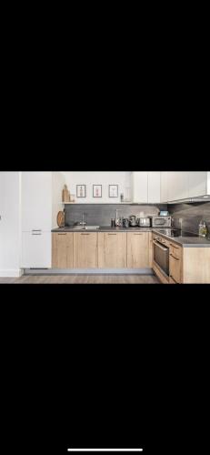 una cocina con armarios de madera y electrodomésticos de acero inoxidable en Solihull Town Centre Spacious Studio Apartment en Solihull